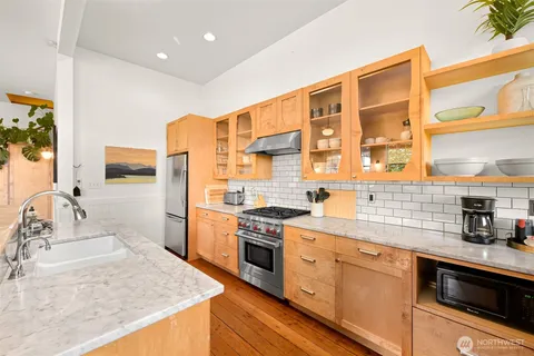 a kitchen with stainless steel appliances granite countertop a sink and stove top oven