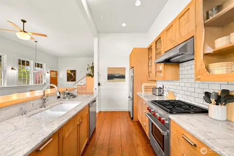 a kitchen with stainless steel appliances granite countertop sink stove and refrigerator
