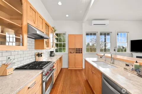 a large kitchen with stainless steel appliances granite countertop a large stove a sink and a refrigerator