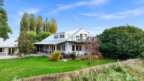 a view of a house with a big yard potted plants and large tree