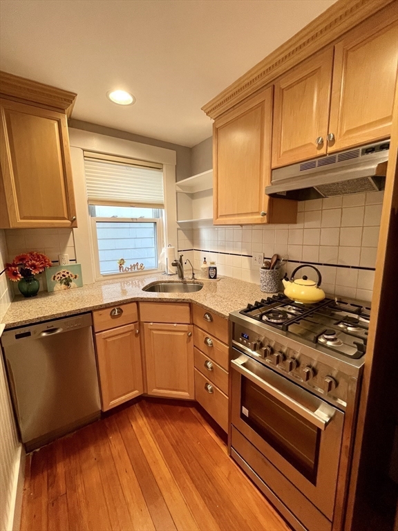 1 Green Street, Unit 2 Marblehead, MA 01945 - Photo 14 of 31 a kitchen with granite countertop wooden cabinets stainless steel appliances and a sink
