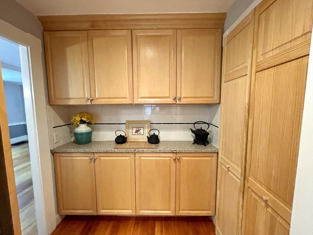 1 Green Street, Unit 2 Marblehead, MA 01945 - Photo 17 of 31 a close view of a sink a washer and dryer with wooden cabinets