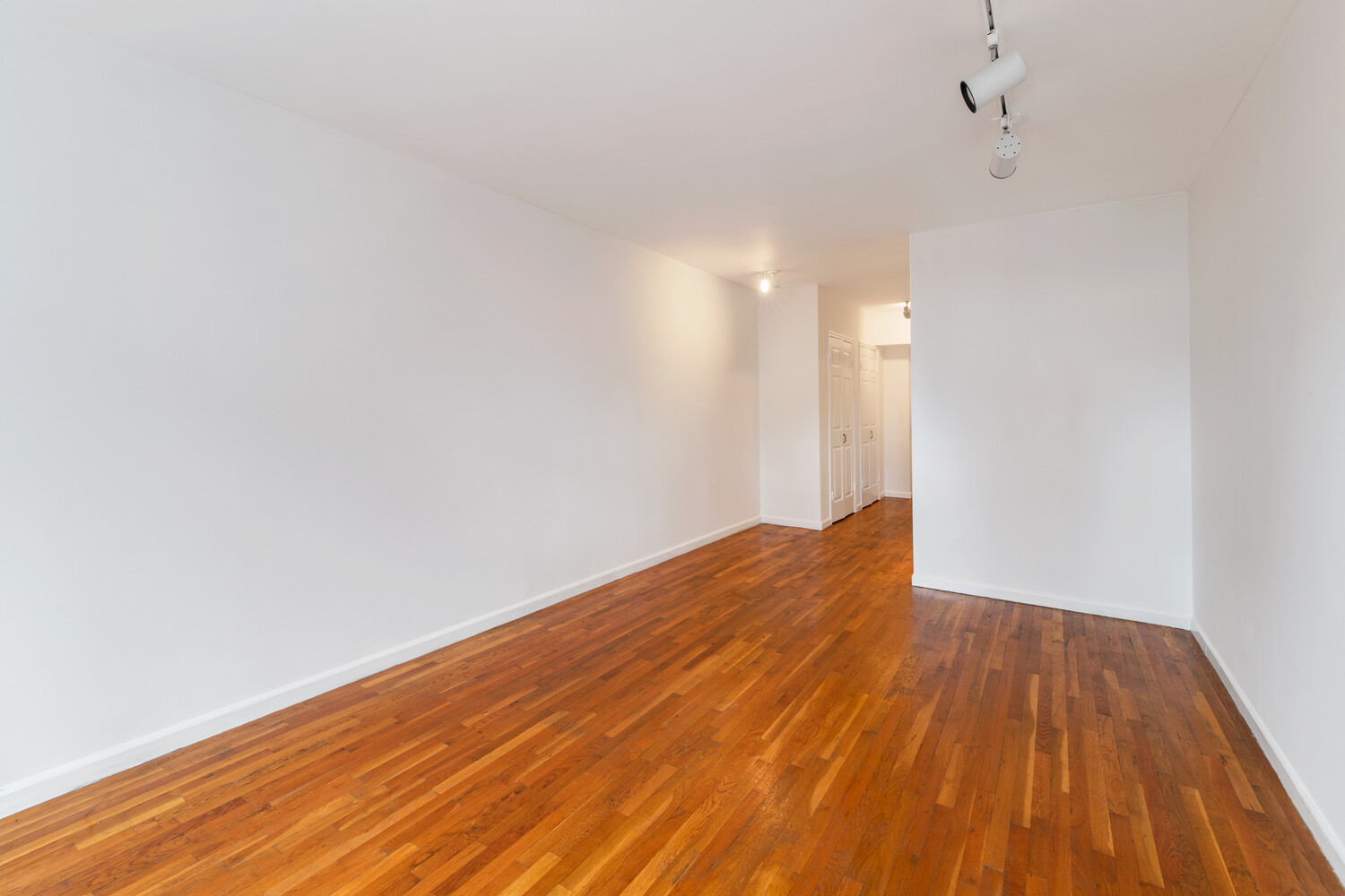 186 West 80th Street, Unit 6H Manhattan, NY 10024 - Photo 3 of 10 a view of empty room with wooden floor and fan