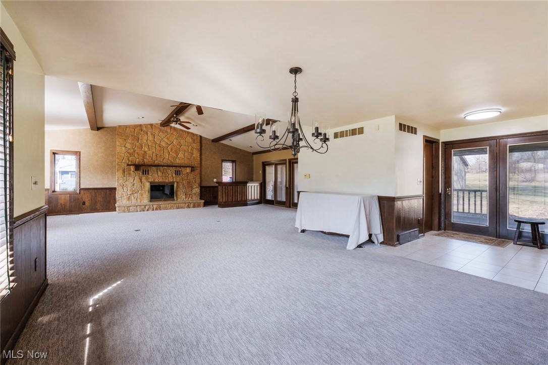 7059 Stewart Sharon Road Hubbard, OH 44425 - Photo 14 of 49 Unfurnished living room featuring lofted ceiling with beams, a wainscoted wall, carpet floors, and visible vents