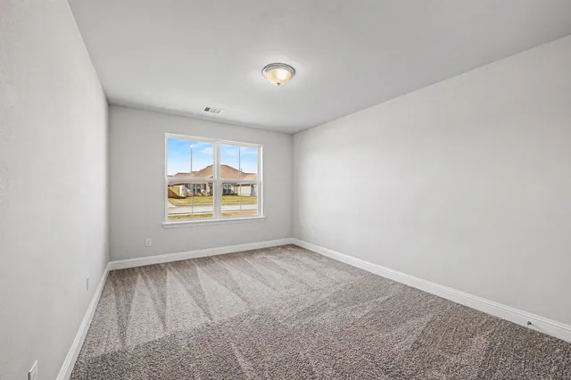 a view of an empty room with a window and closet