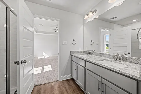 a bathroom with a granite countertop sink a mirror and a shower
