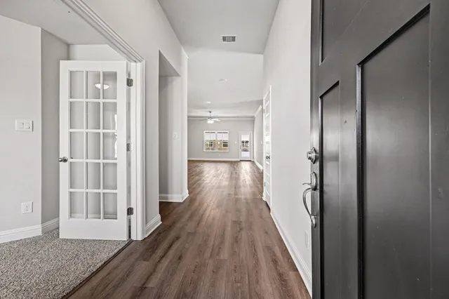a view of a hallway with wooden floor and staircase