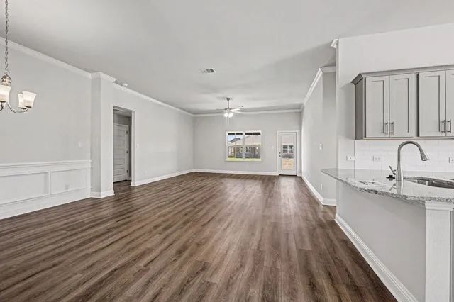 a view of empty room with kitchen and window