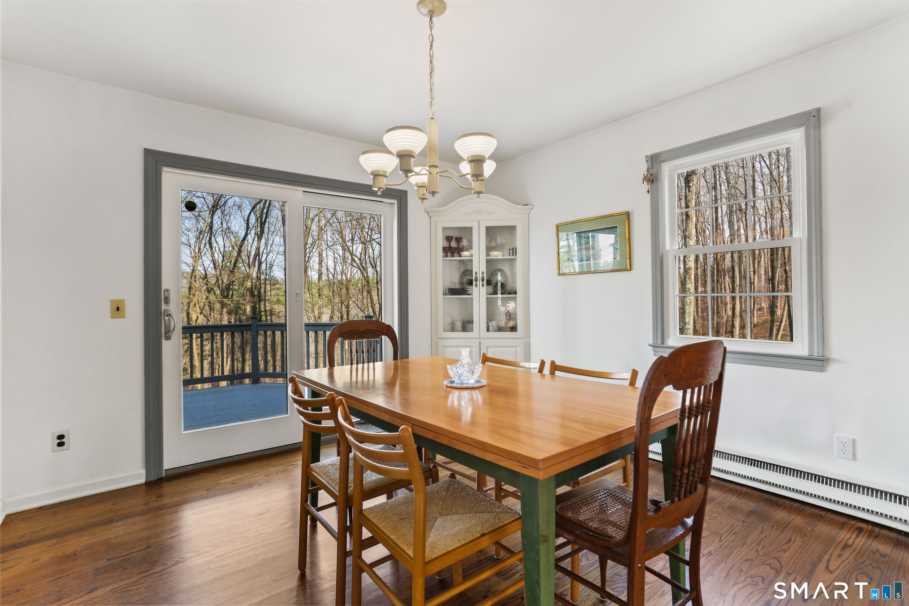 268 Umpawaug Road Redding, CT 06896 - Photo 5 of 30 a dining room with wooden floor a chandelier a wooden table and chairs