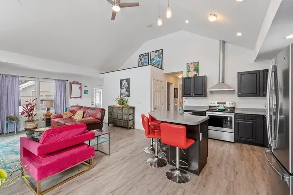 a living room with patio furniture and a kitchen