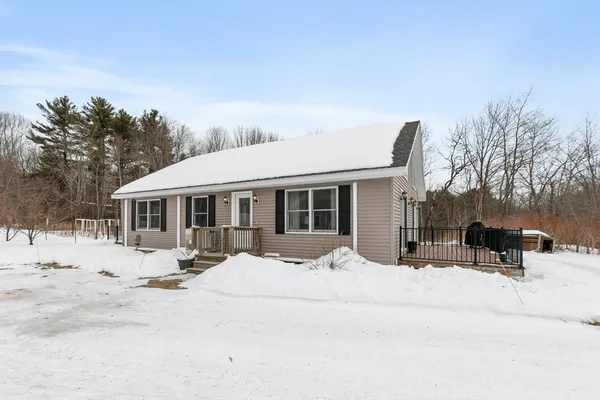 a front view of a house with a yard covered in snow