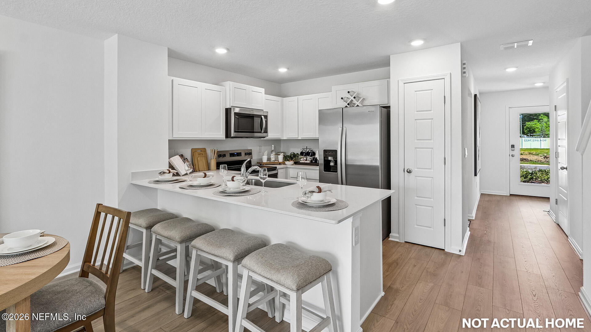 3625 Prancer Point Middleburg, FL 32068 - Photo 8 of 38 a kitchen with stainless steel appliances kitchen island granite countertop a refrigerator and a dining table with wooden floor
