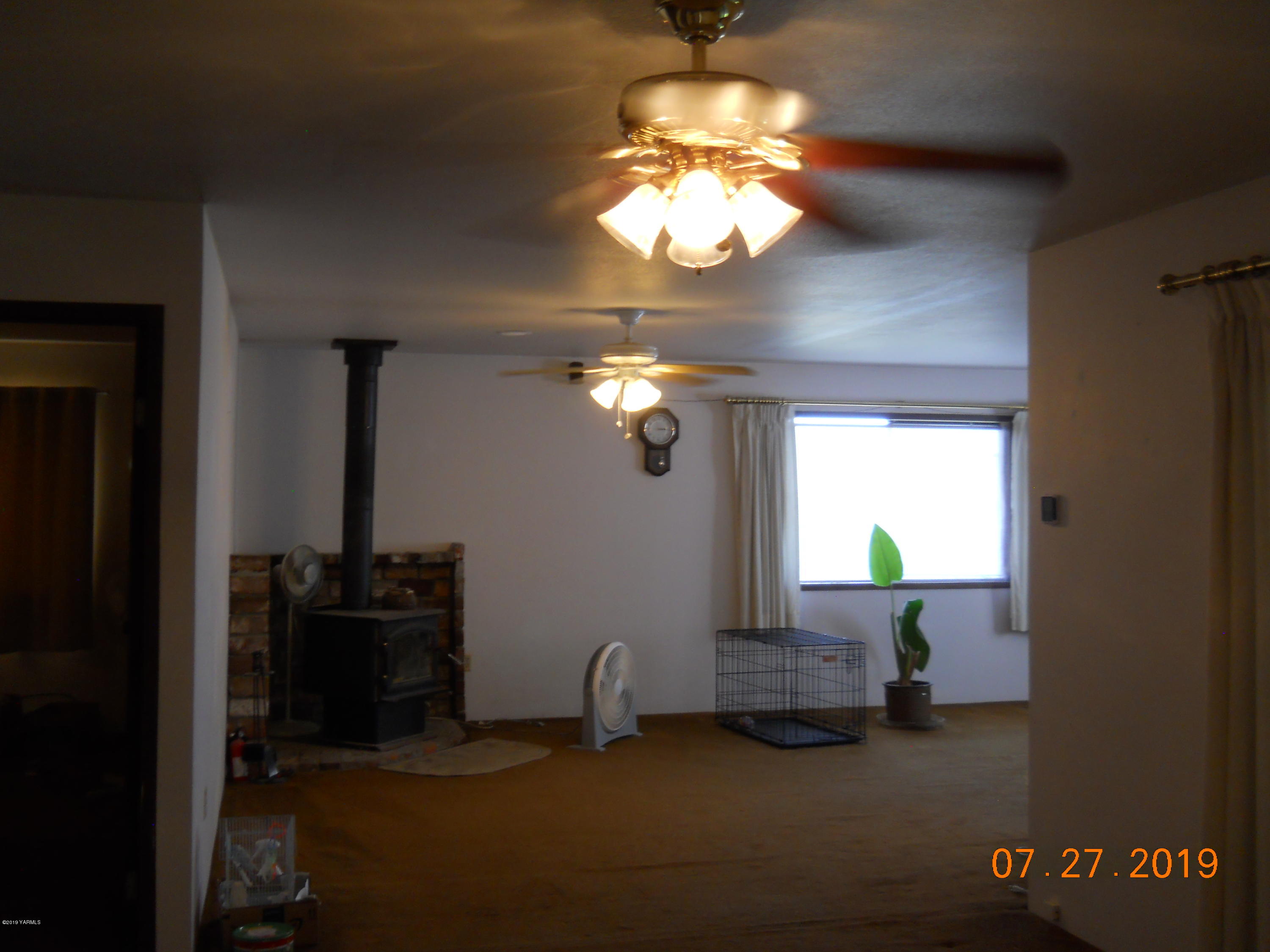 221 Rader Road Sunnyside, WA 98944 - Photo 4 of 13 a view of a livingroom with furniture and chandelier fan