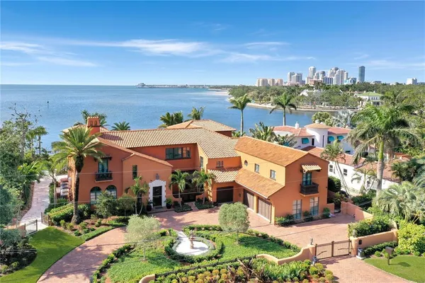 a front view of a house with a yard and lake view