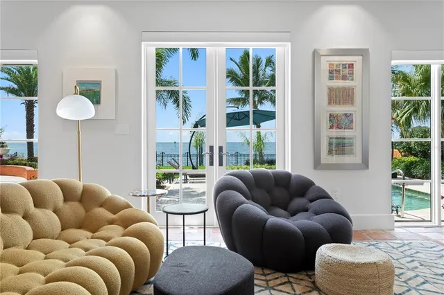 a hall way with furniture a rug and a chandelier