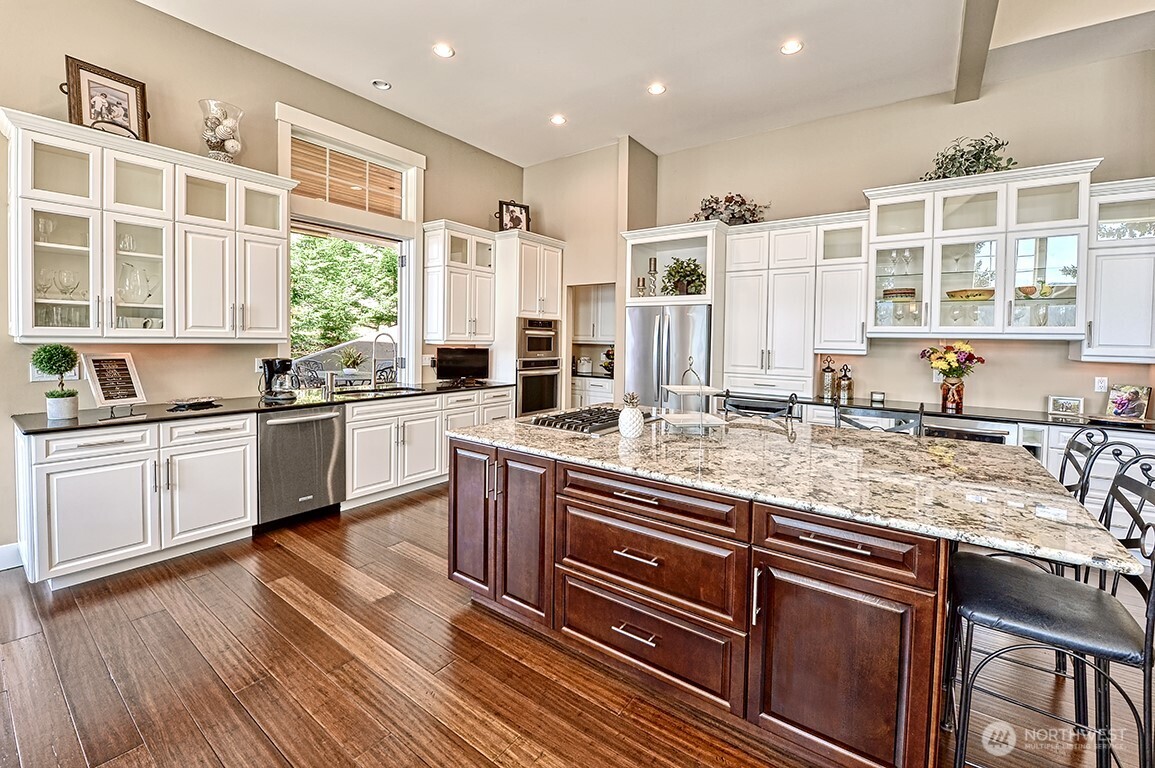 3042 North Shore Road Bellingham, WA 98226 - Photo 7 of 35 a kitchen with stainless steel appliances granite countertop a stove a sink dishwasher a refrigerator and white cabinets with wooden floor