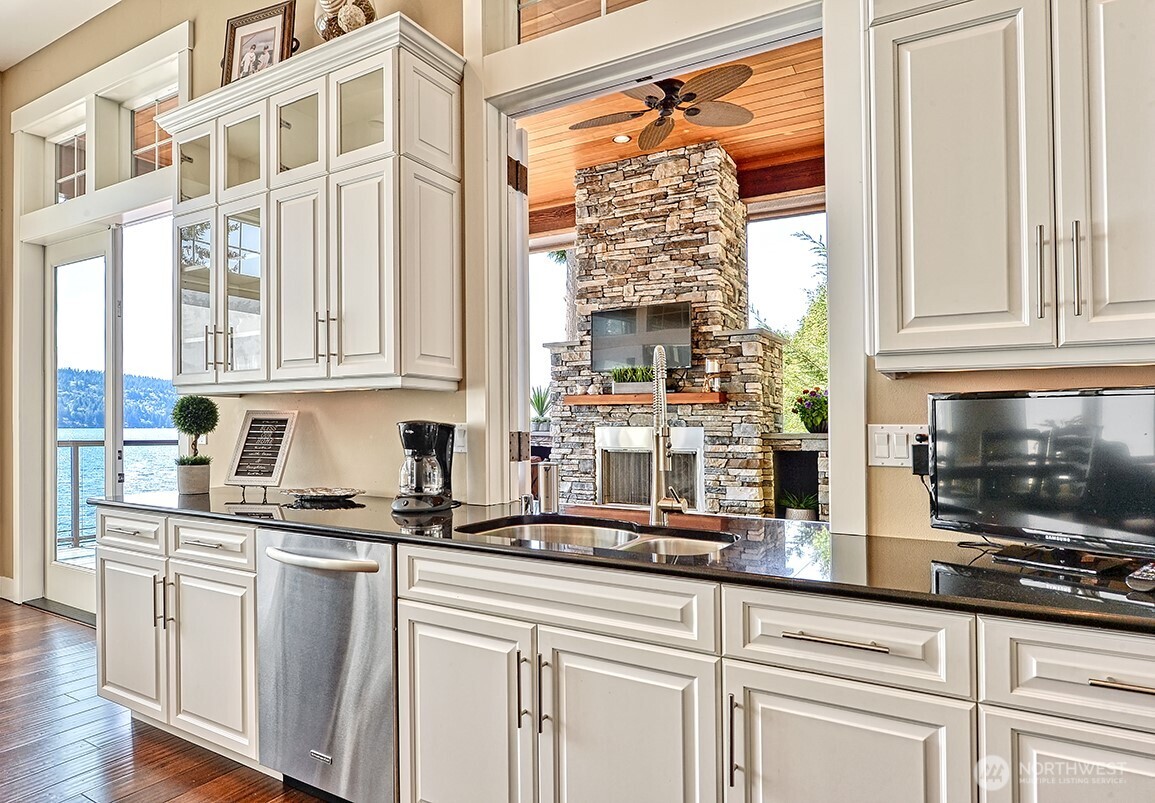 3042 North Shore Road Bellingham, WA 98226 - Photo 9 of 35 a kitchen with stainless steel appliances granite countertop a coffee maker a sink and white cabinets