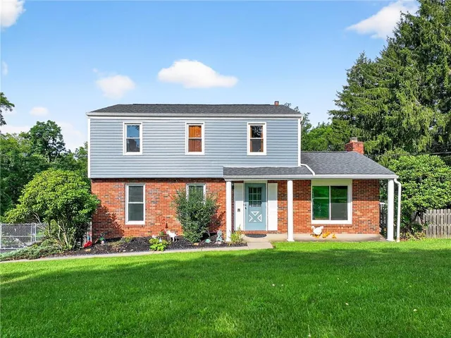 a front view of a house with a garden and yard