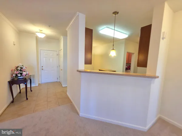 a view of a hallway with two chair and a chandelier