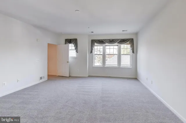 an empty room with windows and closet in it