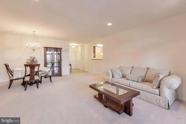 a living room with furniture and a dining table with kitchen view