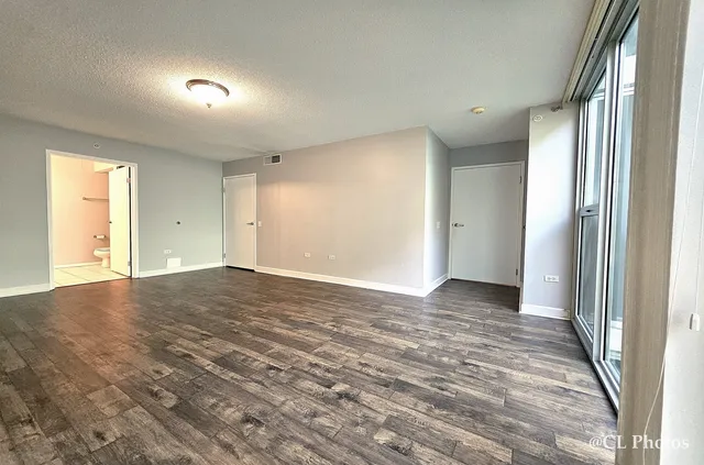 a view of an empty room and window and wooden floor