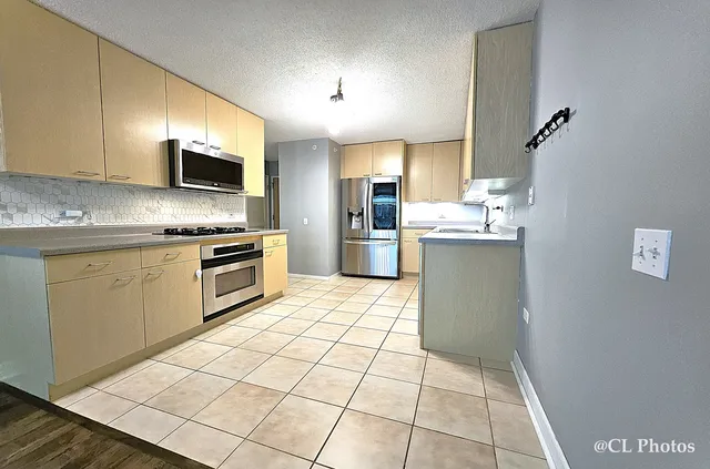 a kitchen with a sink a stove top oven and cabinetry
