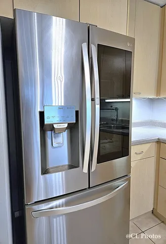 a view of a refrigerator in kitchen and stainless steel appliances wooden floor
