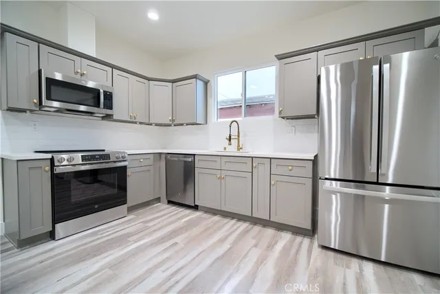 a kitchen with cabinets stainless steel appliances and a sink