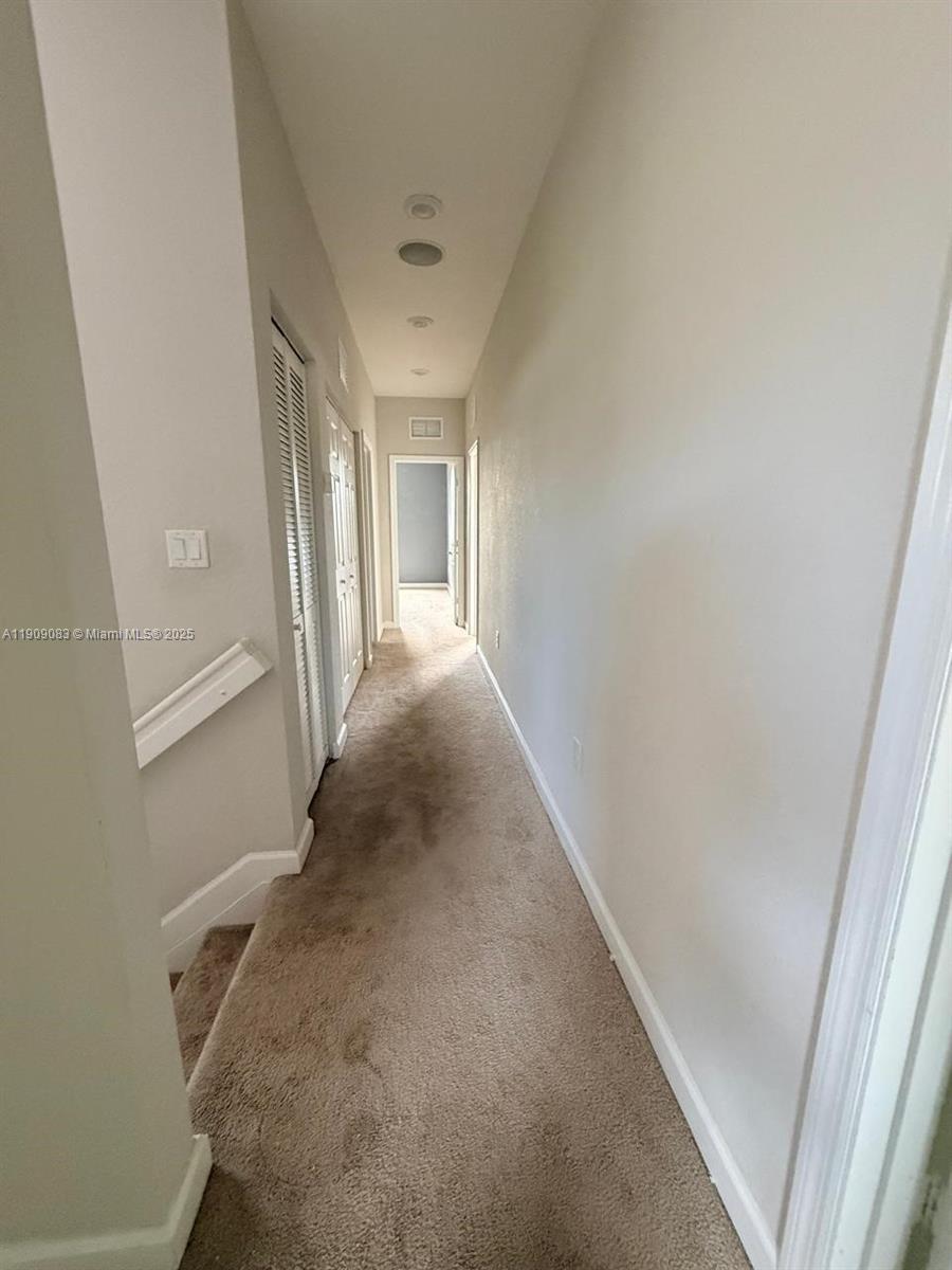 12715 Southwest 230th Terrace, Unit 1 Miami, FL 33170 - Photo 14 of 24 a view of a hallway to a bedroom