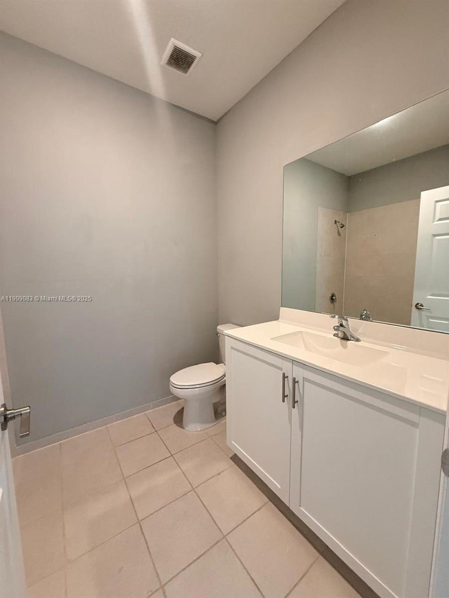 12715 Southwest 230th Terrace, Unit 1 Miami, FL 33170 - Photo 21 of 24 a spacious bathroom with a granite countertop toilet and sink
