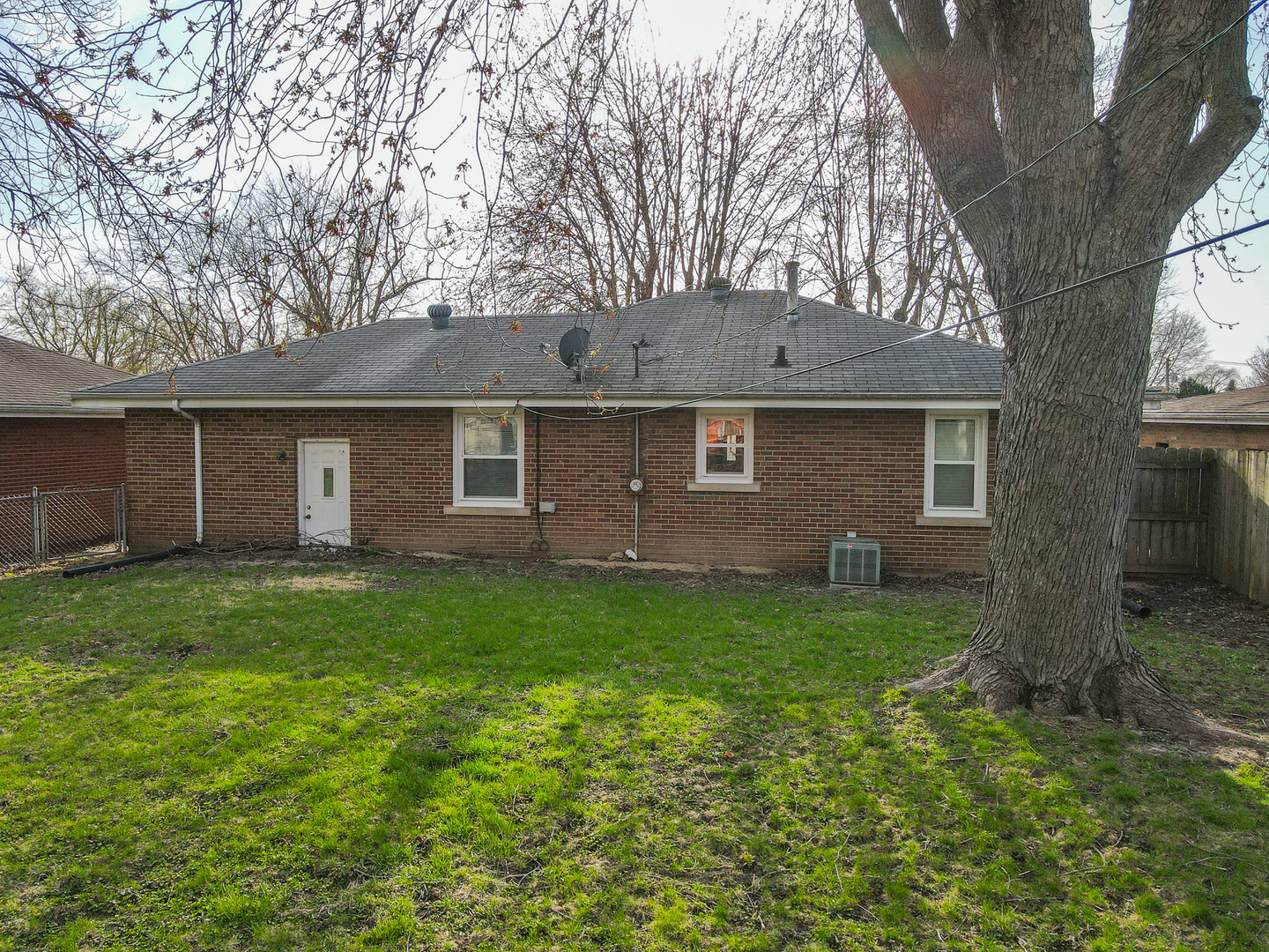 304 Ashley Avenue Bourbonnais, IL 60914 - Photo 15 of 18 a view of a yard in front of a house with large tree