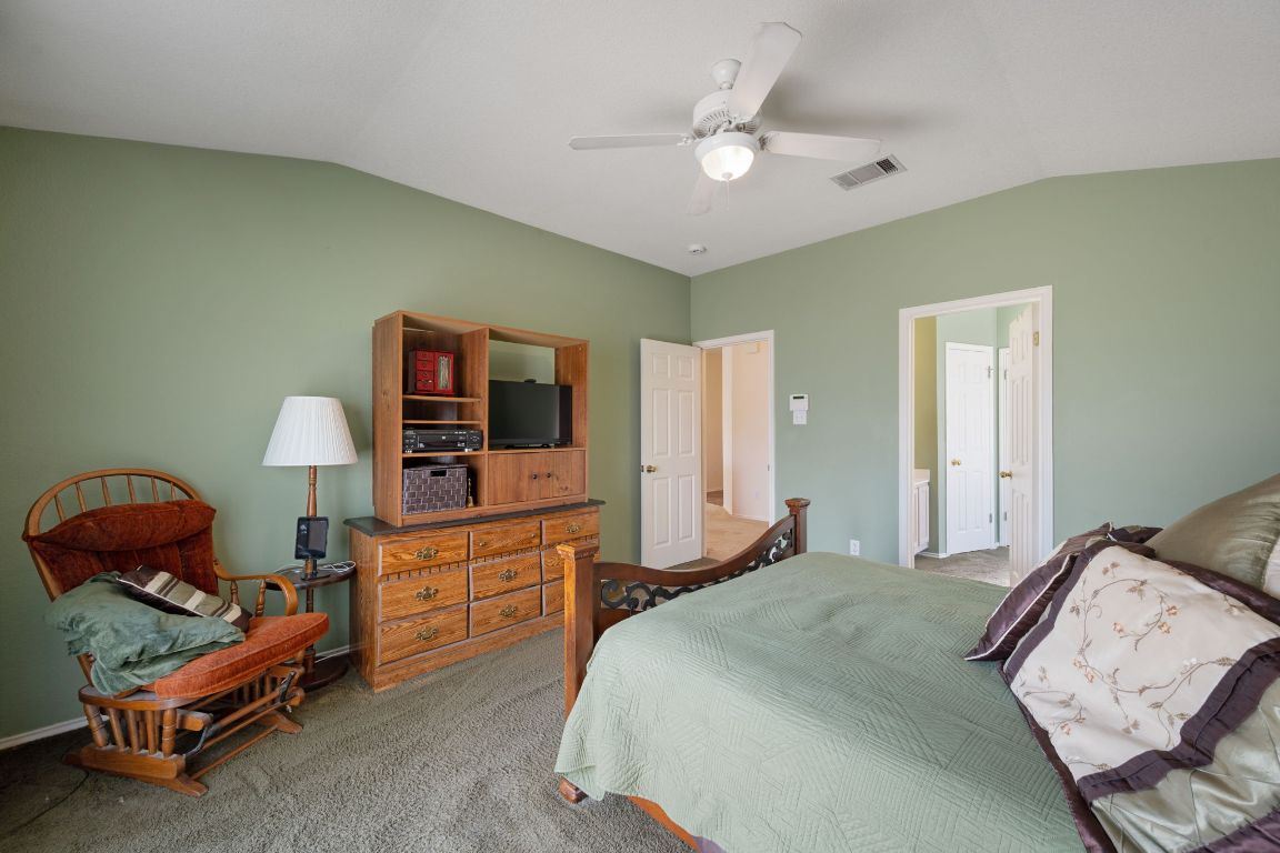 14505 Sandifer Street Austin, TX 78725 - Photo 13 of 28 a bedroom with a bed and a chandelier