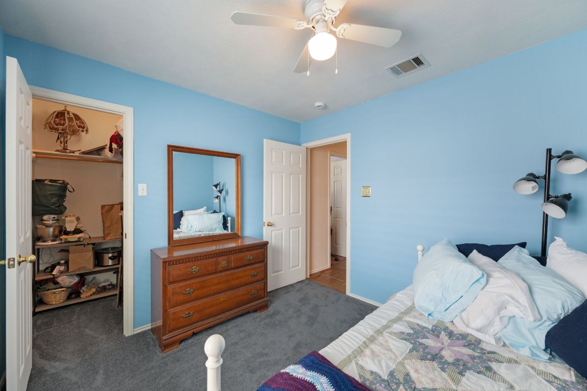 14505 Sandifer Street Austin, TX 78725 - Photo 20 of 28 a bedroom with a bed and a chandelier