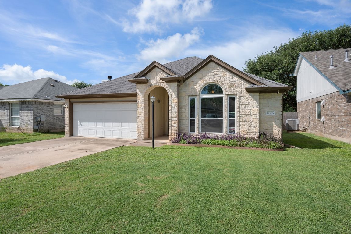 14505 Sandifer Street Austin, TX 78725 - Photo 2 of 28 a front view of a house with a garden and yard
