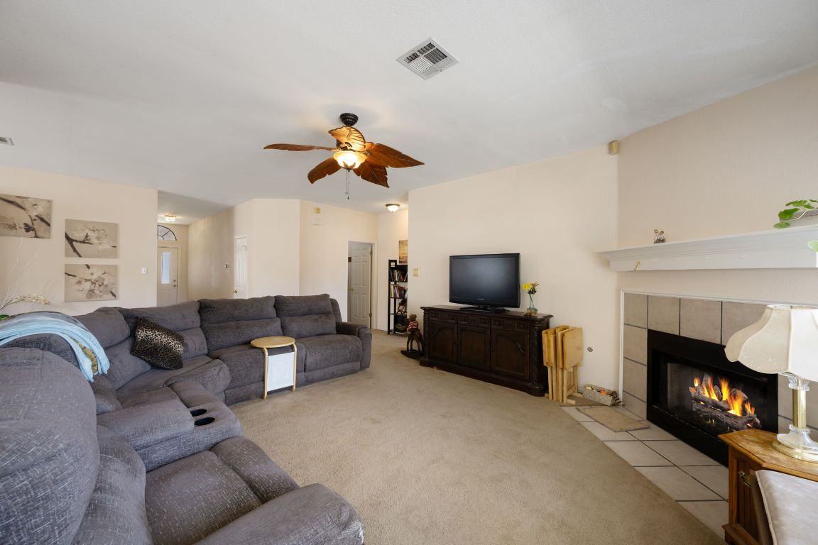 14505 Sandifer Street Austin, TX 78725 - Photo 5 of 28 a living room with furniture a fireplace and a flat screen tv