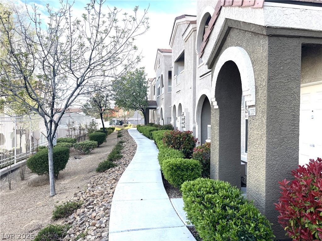 10001 Peace Way, Unit 1327 Las Vegas, NV 89147 - Photo 2 of 21 A graceful curved walkway guides visitors along the building's façade, flanked by meticulously maintained landscaping.