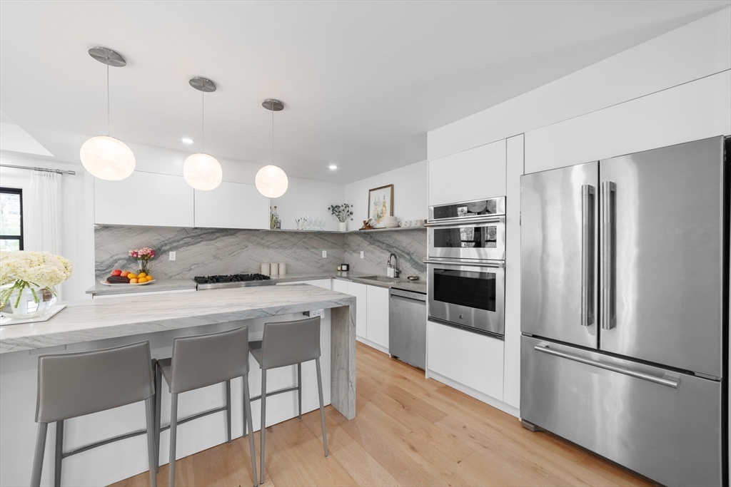 45 Rowena Road Newton, MA 02459 - Photo 11 of 42 a kitchen with kitchen island a refrigerator stove and microwave