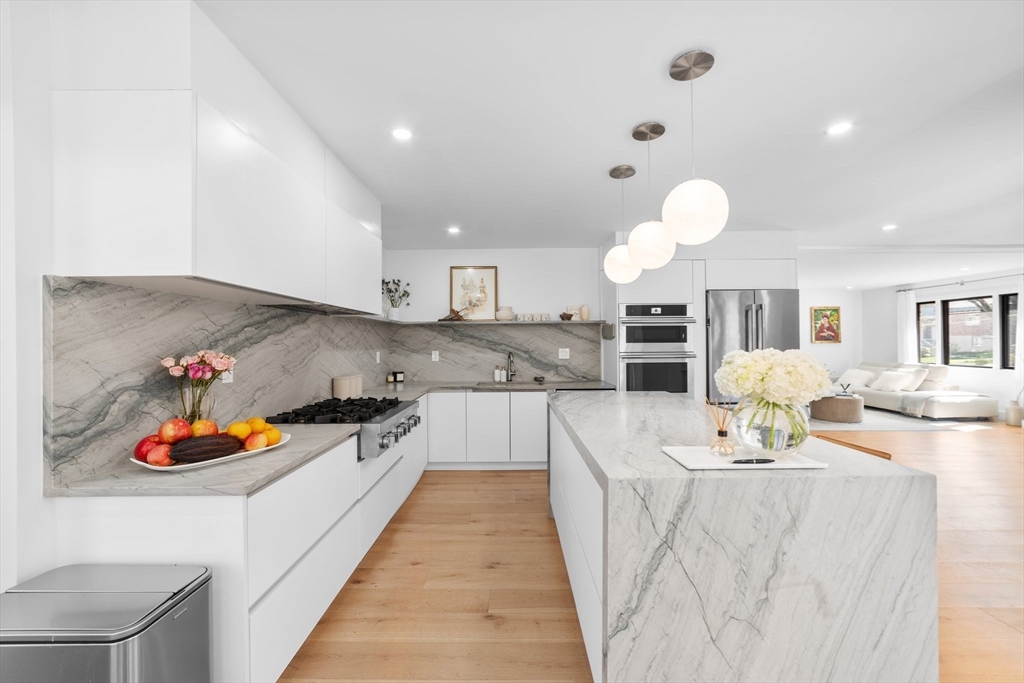 45 Rowena Road Newton, MA 02459 - Photo 13 of 42 a large kitchen with kitchen island stainless steel appliances a stove a sink dishwasher and cabinets with wooden floor