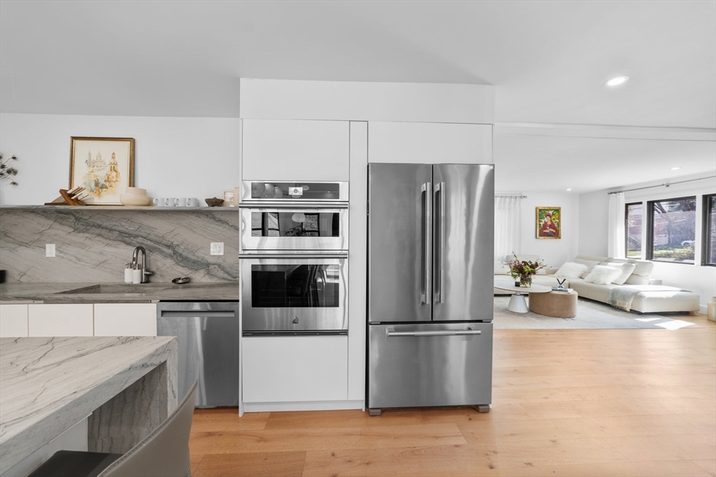 45 Rowena Road Newton, MA 02459 - Photo 14 of 42 a kitchen with stainless steel appliances granite countertop a refrigerator a stove and a sink with wooden floors