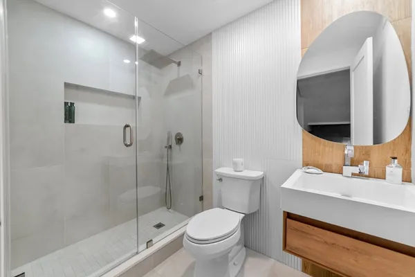a view of bathroom with a sink a mirror and a potted plant