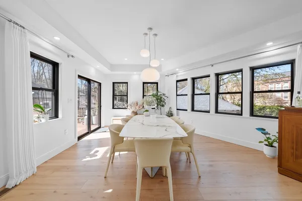 a view of a dining room with furniture a chandelier and wooden floor