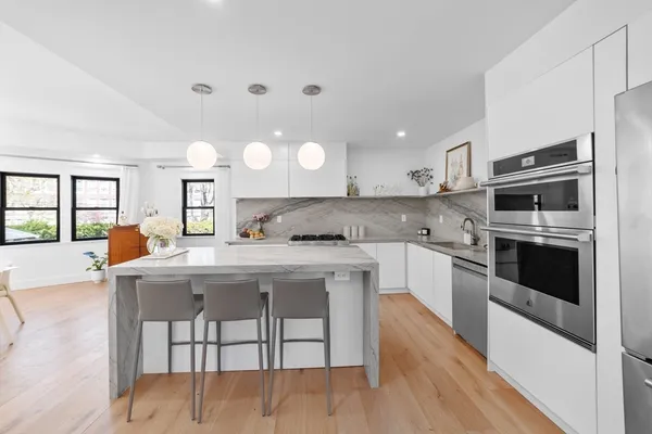a kitchen with kitchen island a refrigerator stove and microwave