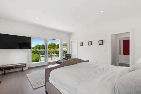 a bedroom with a bed and large window