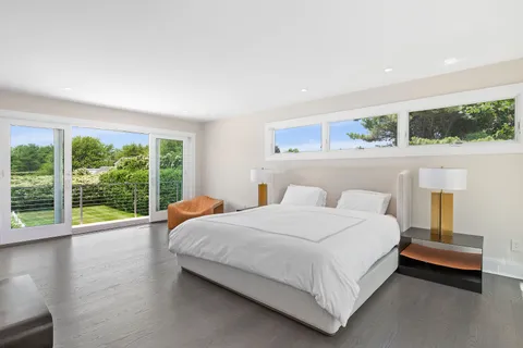 a bedroom with a bed and a large window