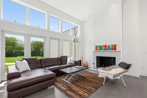 a living room with furniture a fireplace and a large window