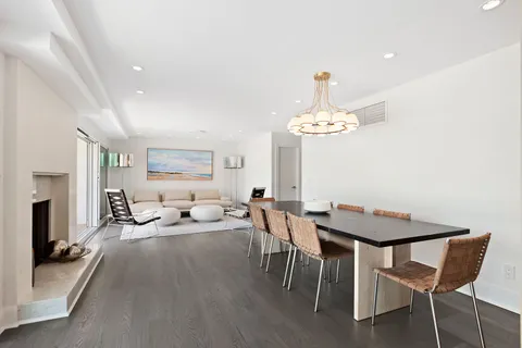 a living room with furniture a chandelier and a dining table