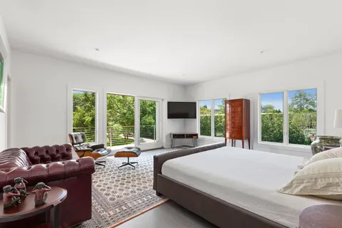 a large bedroom with a bed and large windows