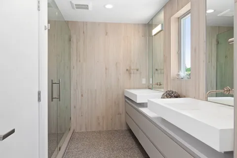 a bathroom with a sink a mirror and a shower