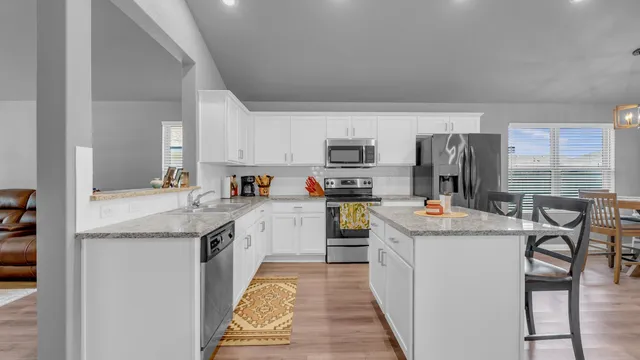a kitchen with stainless steel appliances granite countertop a refrigerator stove microwave and sink
